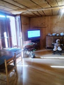 a living room with a tv and a teddy bear at Savoie, Simple mais confortable in Villard-sur-Doron