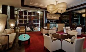 a restaurant with white chairs and tables and a bar at Crowne Plaza Amman, an IHG Hotel in Amman