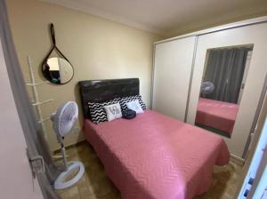ein Schlafzimmer mit einem rosa Bett und einem Spiegel in der Unterkunft Casa temporada in Búzios