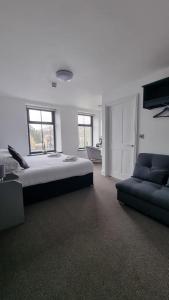 a large bedroom with a bed and a couch at The Friendship Hotel in Stocksbridge