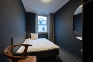 a small bedroom with a bed and a window at Hotel Maritime in Copenhagen