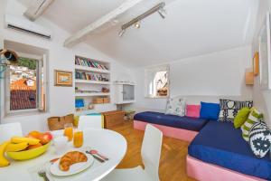 a living room with a table and a blue couch at Arty Apartments in the Heart of Dubrovnik by Irundo in Dubrovnik