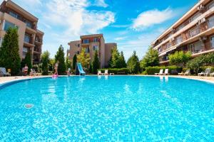 a large swimming pool with blue tiles in a building at Nessebar and Holiday Fort Apartments in Sunny Beach