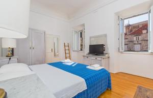 a white bedroom with two beds and a television at Arty Apartments in the Heart of Dubrovnik by Irundo in Dubrovnik