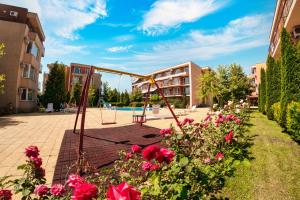 a playground with flowers in front of a building at Nessebar and Holiday Fort Apartments in Sunny Beach