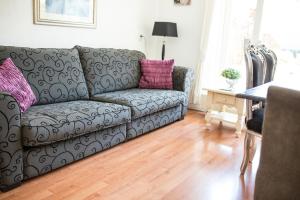 sala de estar con sofá gris y almohadas rosas en Apartment Seastar Zandvoort, en Zandvoort