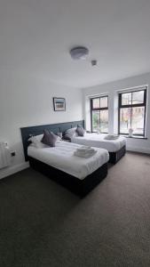 - 2 lits dans une chambre avec 2 fenêtres dans l'établissement The Friendship Hotel, à Stocksbridge