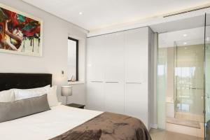 a bedroom with a bed and a glass wall at Park Central Loft Apartment in Rosebank in Johannesburg