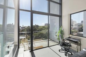 an office with a view of a room with windows at Park Central Loft Apartment in Rosebank in Johannesburg