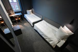 a small room with a bed and a desk with a window at Hotel Maritime in Copenhagen