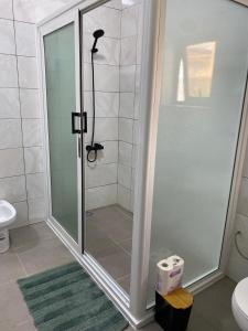 een douche met een glazen deur in de badkamer bij Cozy Apartment in Cotonou