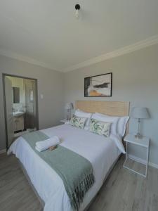 um quarto branco com uma grande cama branca com almofadas em The Comfy Corner @ Skyfall Country Estate em Polokwane