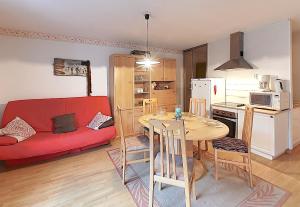 een woonkamer met een tafel en een rode bank bij Les Oursons - Station de ski accessible à pied in La Bresse +7 foto's