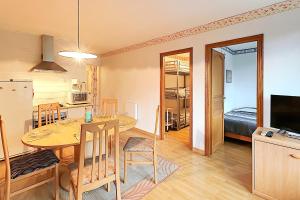 een keuken en een woonkamer met een tafel en een eetkamer bij Les Oursons - Station de ski accessible à pied in La Bresse