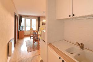 een keuken met een wastafel en een eetkamer bij Les Oursons - Station de ski accessible à pied in La Bresse