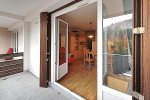 a sliding glass door leading to a room with a bedroom at Les Oursons - Station de ski accessible à pied in La Bresse