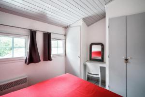 Schlafzimmer mit einem roten Bett und einem Schreibtisch in der Unterkunft Village Moliets - maeva Home - Appartement 3 Pièces 7 Personnes - Sélection MAE-2750 in Moliets-et-Maa + 24 Fotos