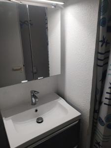 ein Waschbecken mit Spiegel und Duschvorhang in der Unterkunft Village Moliets - maeva Home - Appartement 3 Pièces 7 Personnes - Sélection MAE-2750 in Moliets-et-Maa