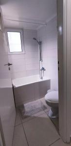 a bathroom with a tub and a toilet and a window at Next to Metro! Bright Apartment with Fully Equipped Kitchen in Athens
