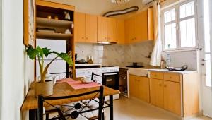 een keuken met houten kasten en een tafel met een plant bij Next to Metro! Bright Apartment with Fully Equipped Kitchen in Athene
