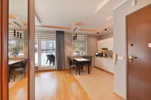 a kitchen and dining room with a table and chairs at Apartamenty Aquamarina SeaView by Rent like home in Międzyzdroje