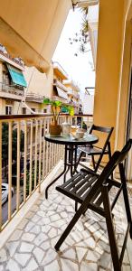 a patio with a table and chairs on a balcony at Next to Metro! Bright Apartment with Fully Equipped Kitchen in Athens
