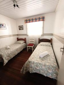 um quarto com duas camas e uma janela em Residencial Di Capri em Gramado