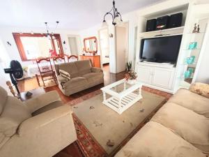 uma sala de estar com dois sofás e uma televisão em Residencial Di Capri em Gramado