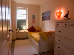 ein kleines Schlafzimmer mit einem Bett und einem Fenster in der Unterkunft Ferienwohnungen Parkstraße in Börgerende-Rethwisch