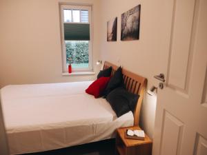 Schlafzimmer mit einem Bett mit weißer Bettwäsche und einem Fenster in der Unterkunft Ferienwohnungen Parkstraße in Börgerende-Rethwisch