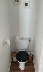 une petite salle de bains avec toilettes et siège noir dans l'établissement Appartement du Cabaliros, à Argelès-Gazost