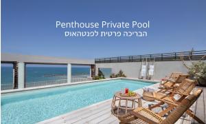 a swimming pool with two chairs and a table next to it at Sea Executive Suites in Tel Aviv