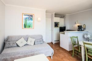 ein Wohnzimmer mit einem Sofa und einer Küche in der Unterkunft Village Pont Royal en Provence - maeva Home - Appartement 2 pièces 6 personn 71 in Mallemort