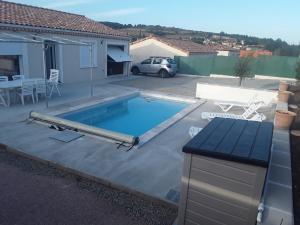 a swimming pool in a yard next to a house at Maison individuelle neuve avec piscine in Limoux