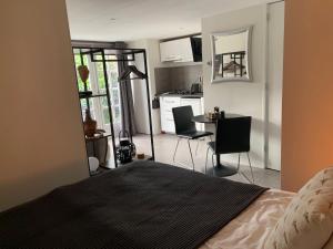 1 dormitorio con cocina y mesa con sillas en Studio@25, en Zandvoort