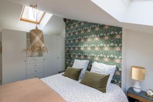 a bedroom with a bed and a green wall at Le Duplex d'Eugenie - Parking - Centre - Clim in Saumur