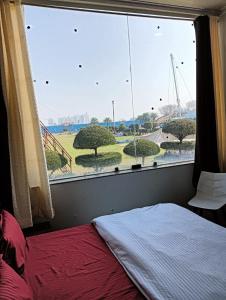 1 dormitorio con ventana grande con vistas a un parque en Krishna fun land, en Mathura