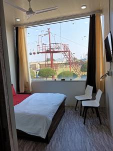 1 dormitorio con cama y ventana grande en Krishna fun land, en Mathura
