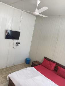 1 dormitorio con 1 cama y TV en la pared en Krishna fun land, en Mathura