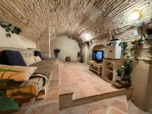a living room with a couch and a tv at Suite con Cueva Romana/Roman Cave * Early Check-in in Toledo
