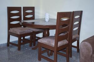 een houten tafel met twee stoelen en een tafel met een doos erop bij Saas Homestay in Eldoret