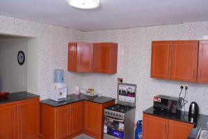 een keuken met houten kasten en een koelkast bij Saas Homestay in Eldoret