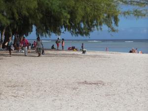 a group of people walking on the beach at Pereybere Beach Villas in Pereybere