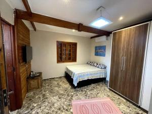 a bedroom with a bed and a television in it at Chácara em Ibiúna com piscina e acesso a represa in Ibiúna +47 photos