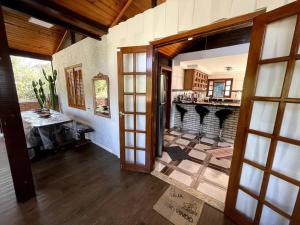 a living room with a fireplace and an open door at Chácara em Ibiúna com piscina e acesso a represa in Ibiúna
