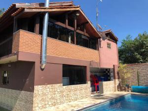 a house with a swimming pool in front of it at Chácara em Ibiúna com piscina e acesso a represa in Ibiúna