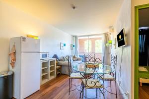 uma sala de estar com uma mesa e um frigorífico em Résidence Saint-Raphaël Valescure - maeva Home - Appartement 3 Pièces 6 Pe 75 em Valescure