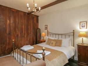 アンブルサイドにあるOld Oak Cottageの木製の壁のベッドルーム1室(ベッド1台付)