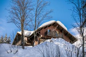 a log cabin with a snow covered roof at Résidence Les Chalets de Puy Saint Vincent - maeva Home - Appartement 2 Piè 51 in Narreyroux