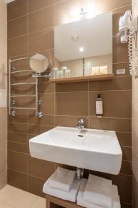 a bathroom with a sink and a mirror at City Hotels Algirdas in Vilnius